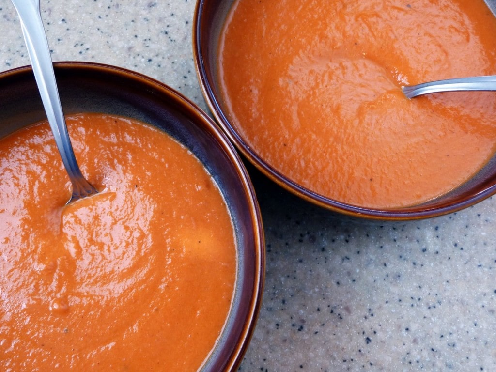 Overhead view of two bowl of homemade cream of tomato soup.