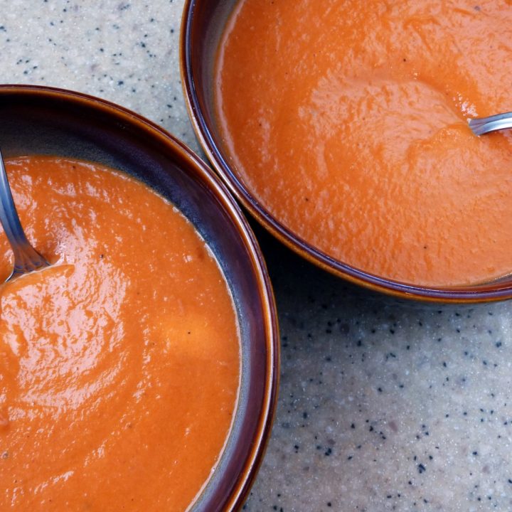 Overhead view of two bowl of homemade cream of tomato soup.