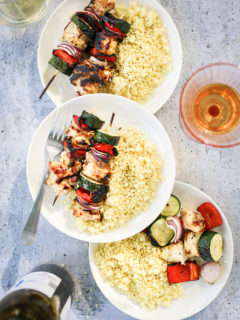plates with grilled chicken kebabs and couscous
