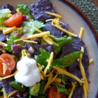 Overhead view of a veggie black bean taco salad on a plate.