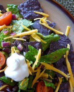 Overhead view of a veggie black bean taco salad on a plate.