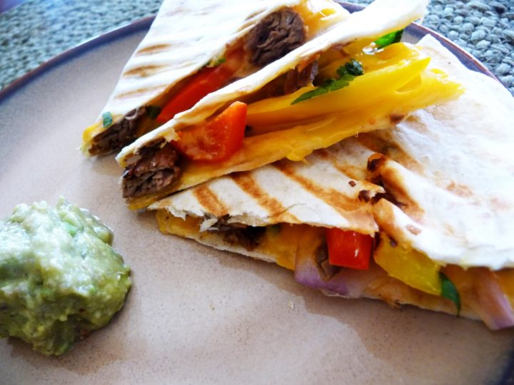 steak quesadilla on a plate with guacamole