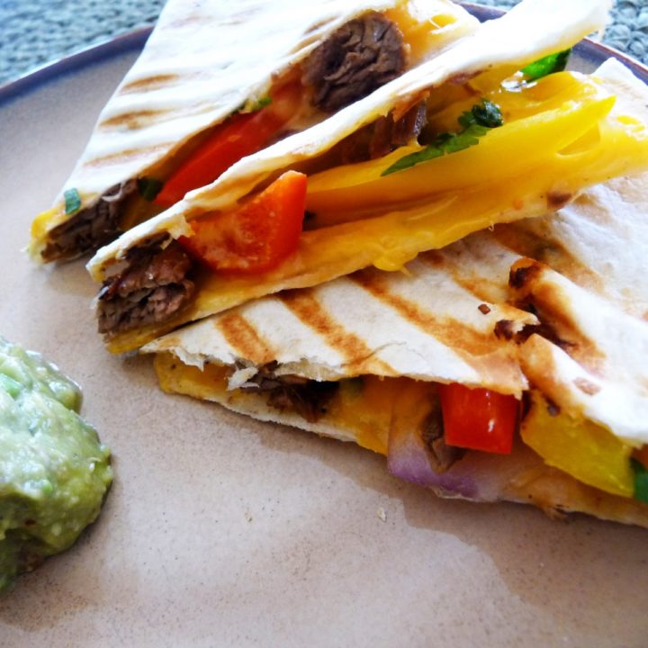 steak quesadilla on a plate with guacamole