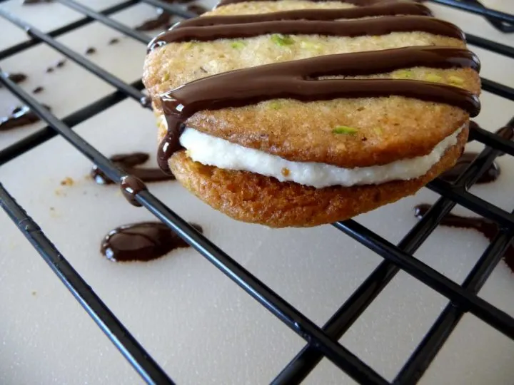 photo of a cannoli cookie on a cookie cooling rack after being drizzled with chocolate