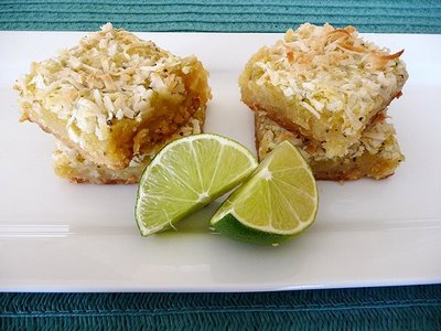 coconut lime bars stacked on a white plate