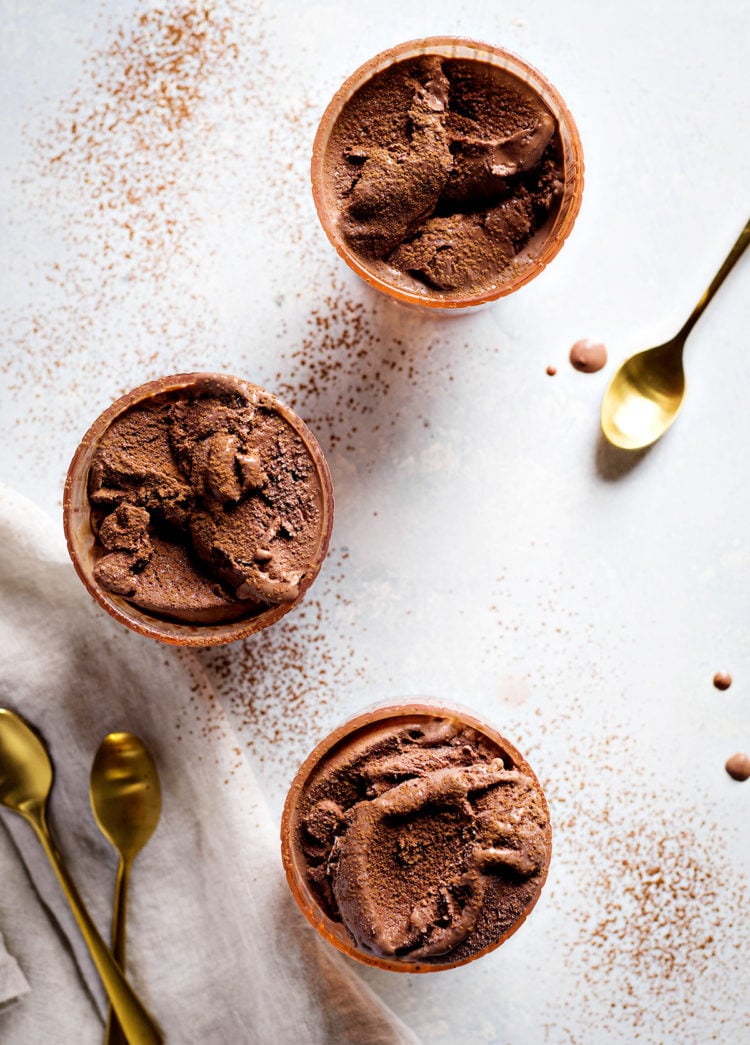 three bowls of chocolate gelato garnished with a dusting of cocoa powder