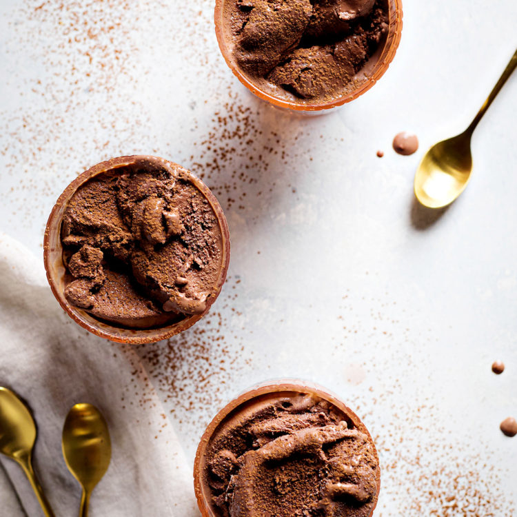 three bowls of chocolate gelato garnished with a dusting of cocoa powder