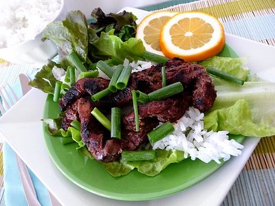 A Korean beef bulgogi lettuce wrap on a green plate.