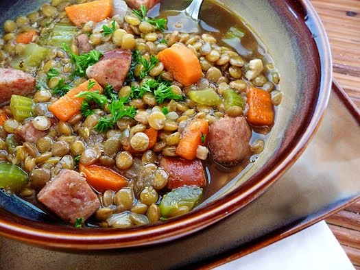 A bowl of smoked sausage and lentil soup. 