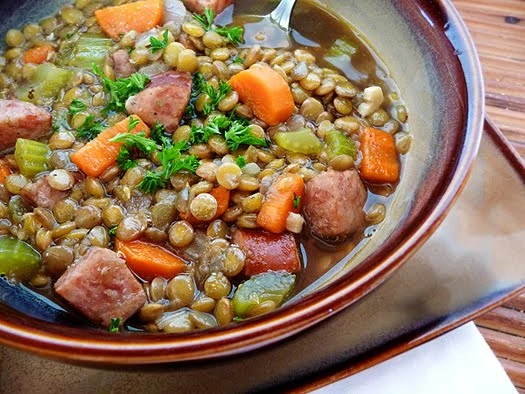 A bowl of smoked sausage and lentil soup.