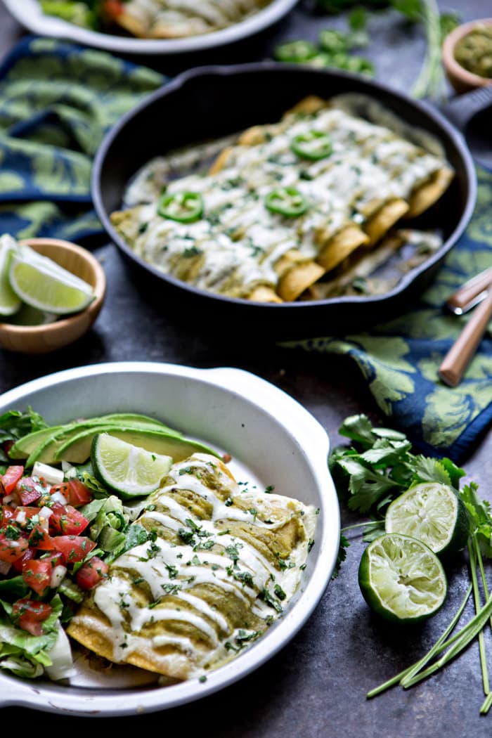 green chicken enchiladas smothered in sour cream sauce and tomatillo sauce 