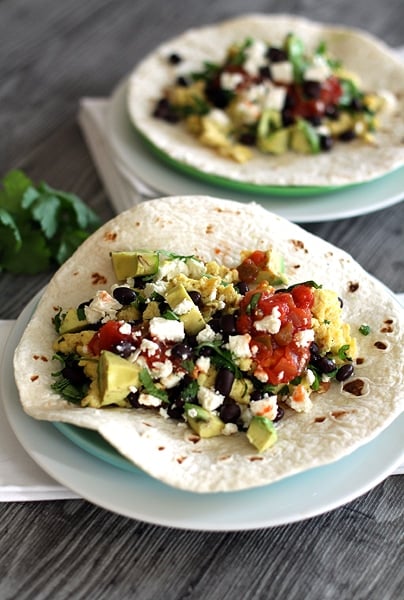 two Black Bean Breakfast Burritos on plates on a table