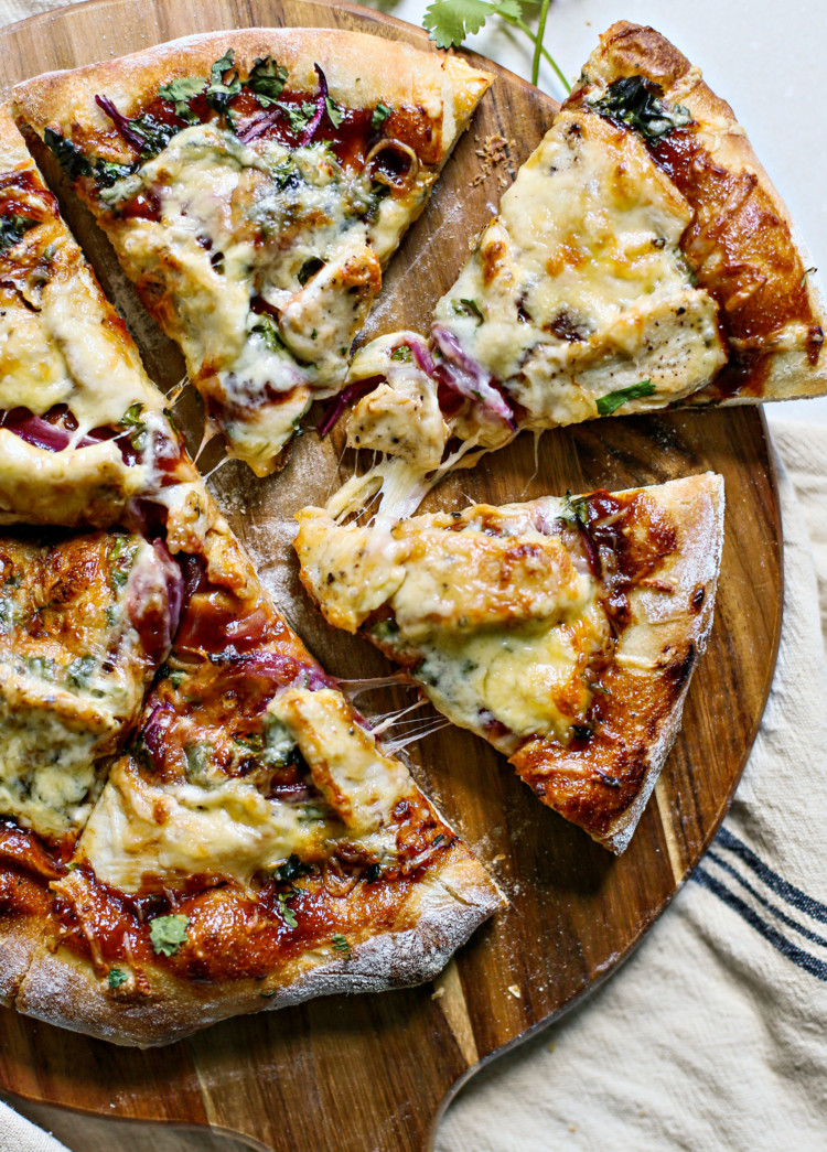 overhead photo of bbq chicken pizza on a wooden pizza peel