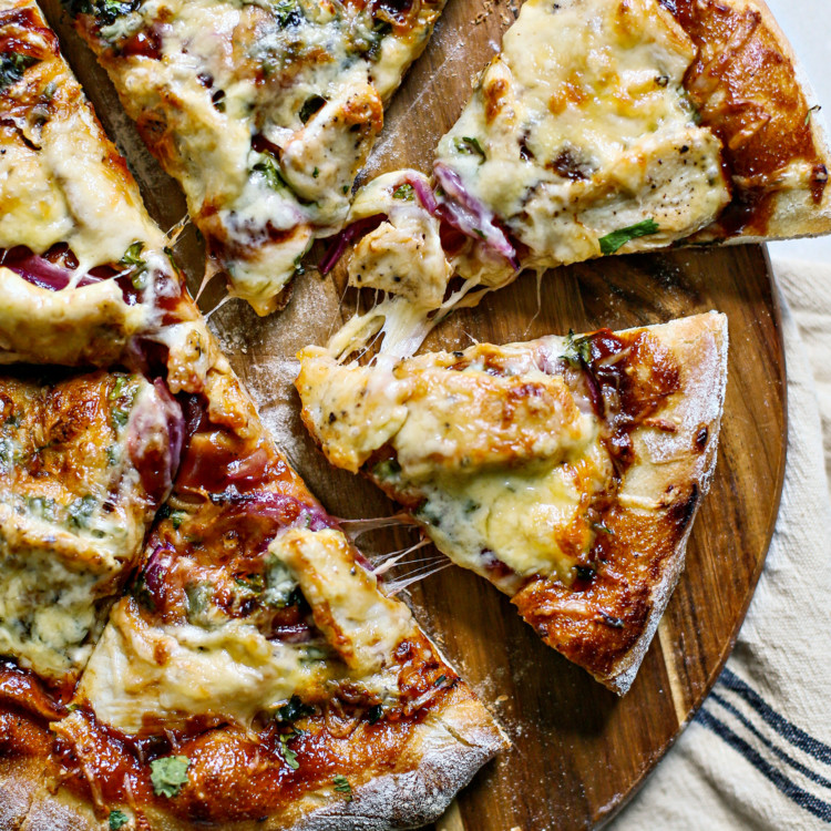 overhead photo of bbq chicken pizza on a wooden pizza peel