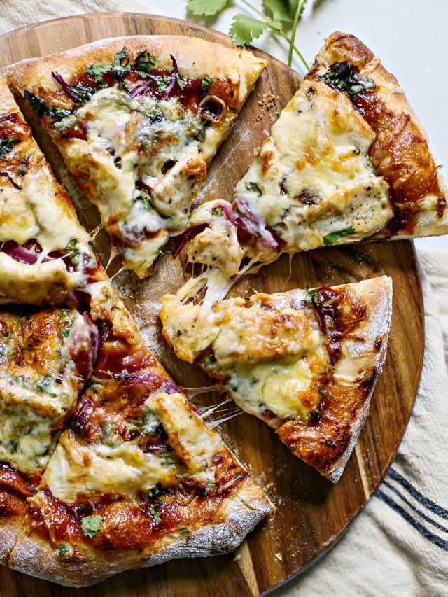 overhead photo of bbq chicken pizza on a wooden pizza peel