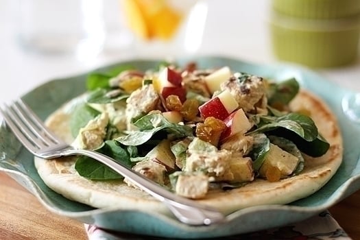 Curried Chicken Salad with Watercress and Apples on a plate with pita and fork