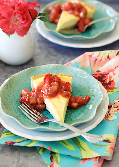 Two slices of lemon curd tart on blue plates. 