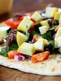 flat bread pizza with zucchini, sausage, peppers, and basil