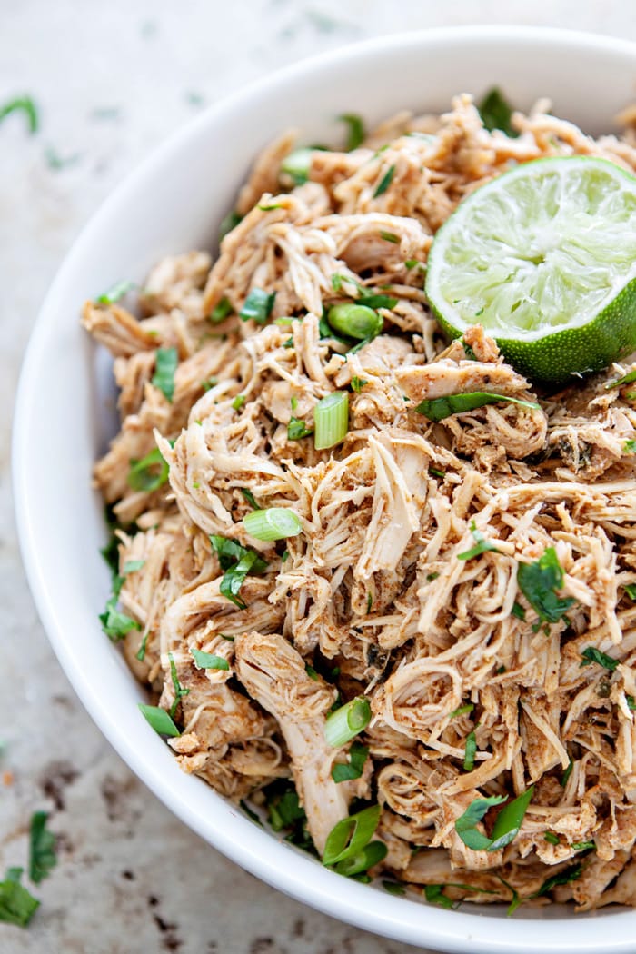 shredded mexican chicken in a white bowl for making a recipe for chipotle chicken wraps