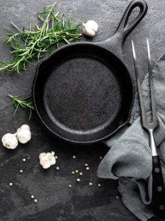 overhead shot of a cast iron pan with herbs and garlic