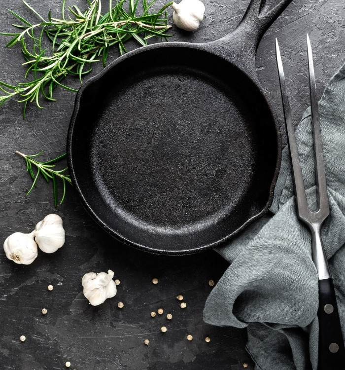 overhead shot of a cast iron pan with herbs and garlic