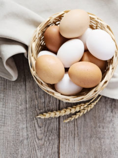 a basket of eggs on a table with cloth
