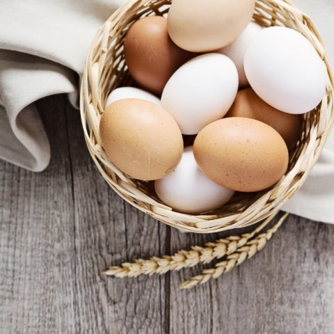 a basket of eggs on a table with cloth