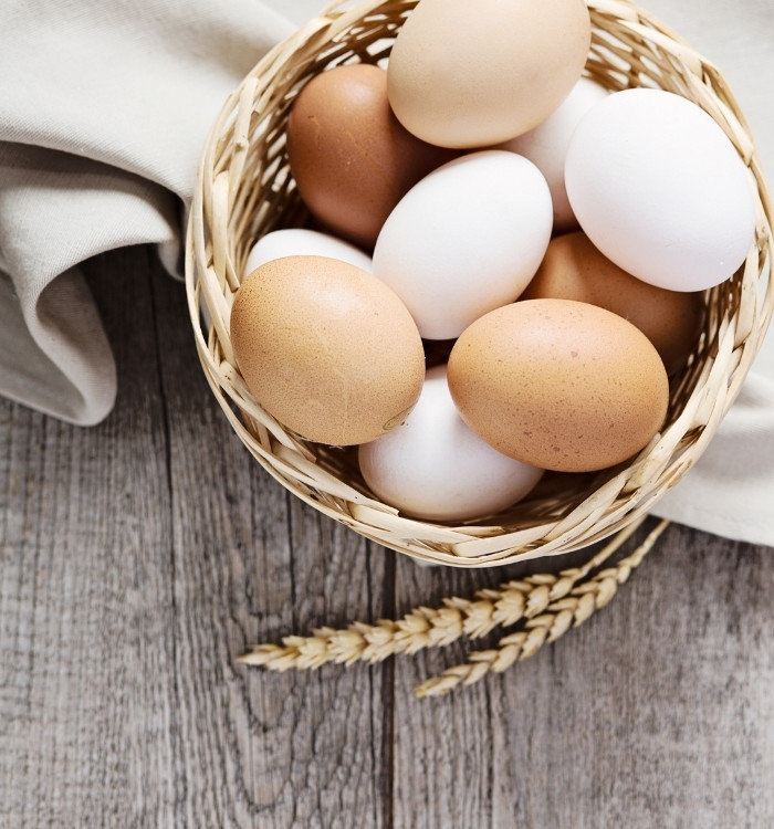 a basket of eggs on a table with cloth