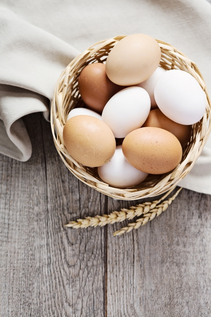 a basket of eggs on a table with cloth