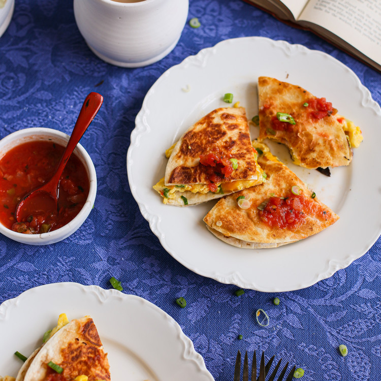 a table set with breakfast quesadillas on two white plates