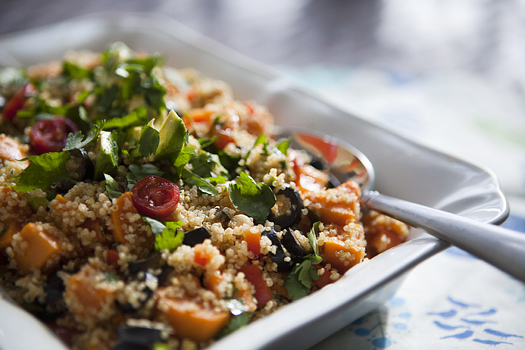 Mexican quinoa salad in a white dish with a spoon. 