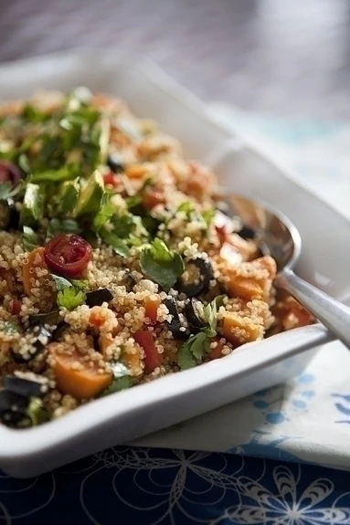 Mexican quinoa salad in a white dish with a spoon. 