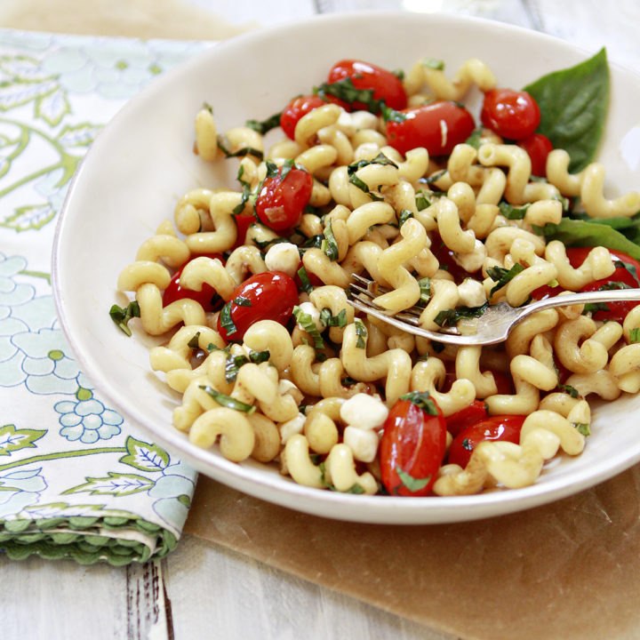 photo of caprese pasta in a white bowl