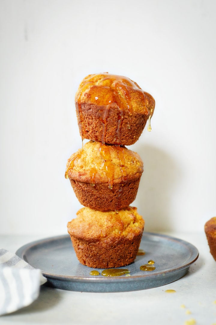 a plate of cornbread muffins with honey drizzled on top