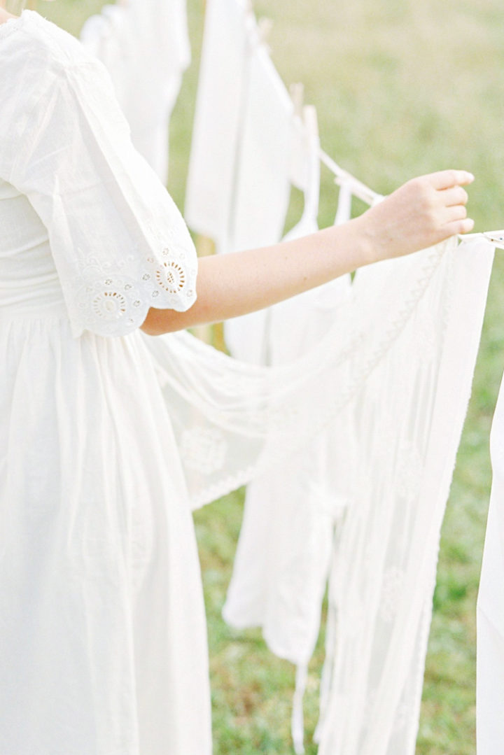 a photo of a woman hanging white laundry to go along with tips for whitening whites