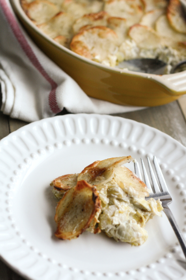 A portion of artichoke, potato and leek casserole on a white plate. 