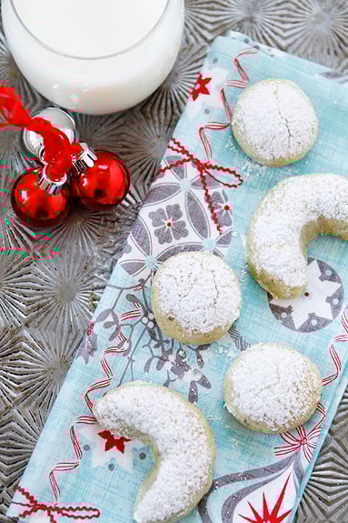 pistachioorangecrescentcookies-2 Overhead view of Orange Pistachio Cookies dusted with powdered sugar on a tray