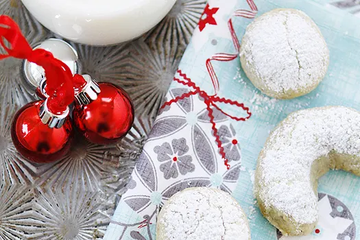 Close up view of Orange Pistachio Christmas Cookies on a blue napkin. 