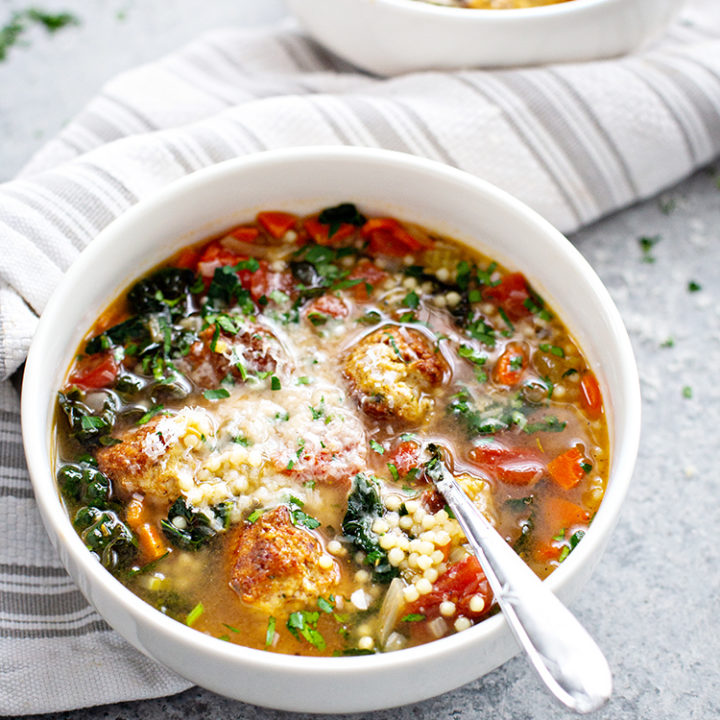 white bowl with italian wedding soup and chicken meatballs