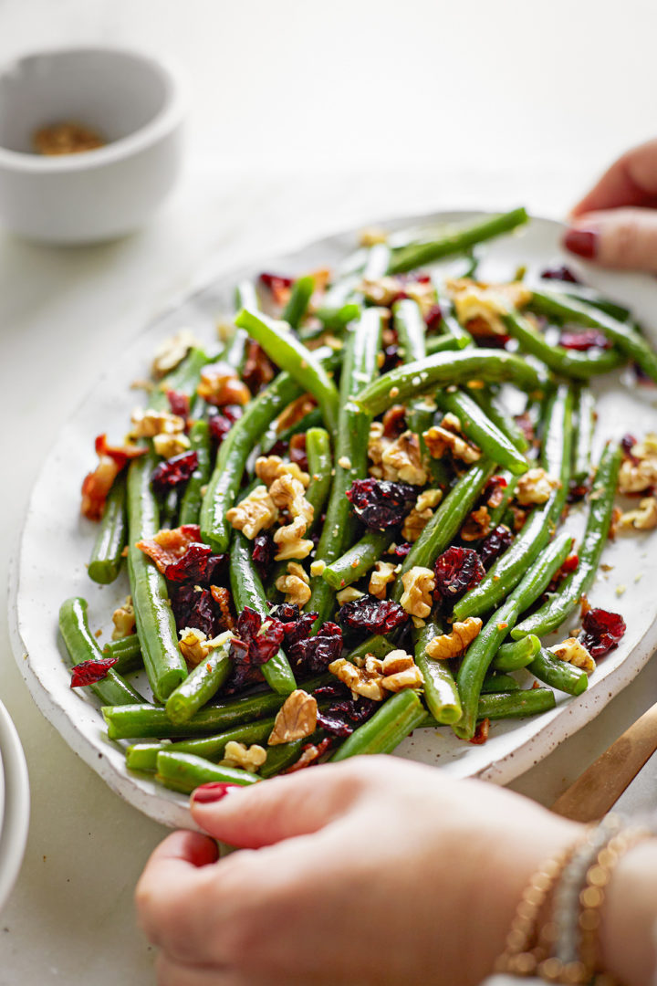 woman holding a platter of green beans for thanksgiving
