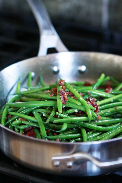 photo of cranberry green beans with walnuts cooking in a stainless steel pan