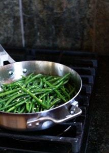 photo of green beans cooking in a stainless steel skillet for a recipe for cranberry green beans with walnuts