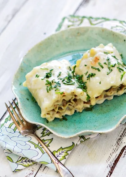 Two chicken lasagna rolls ups on a blue plate 