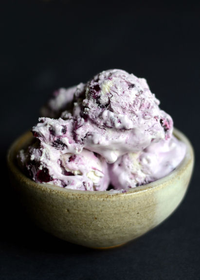 blueberry cheesecake ice cream in a bowl on a black background