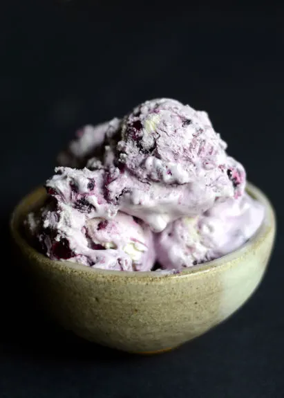 blueberry cheesecake ice cream in a bowl on a black background