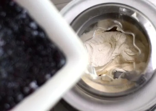 overhead shot of blueberry cheesecake ice cream churning in an ice cream maker