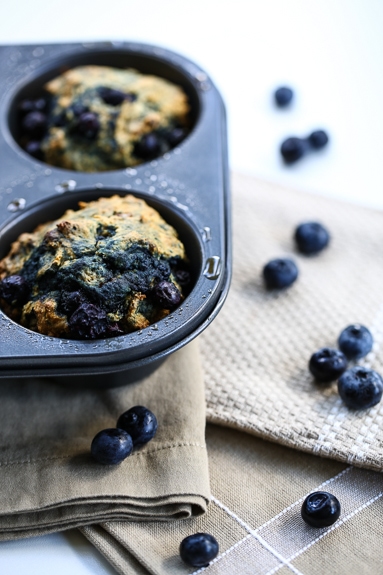 two whole wheat blueberry muffins in muffin tin