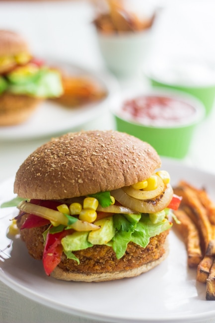 A sweet potato bean burger on a plate with fries. 