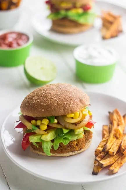 A sweet potato veggie burger on a plate with fries. 