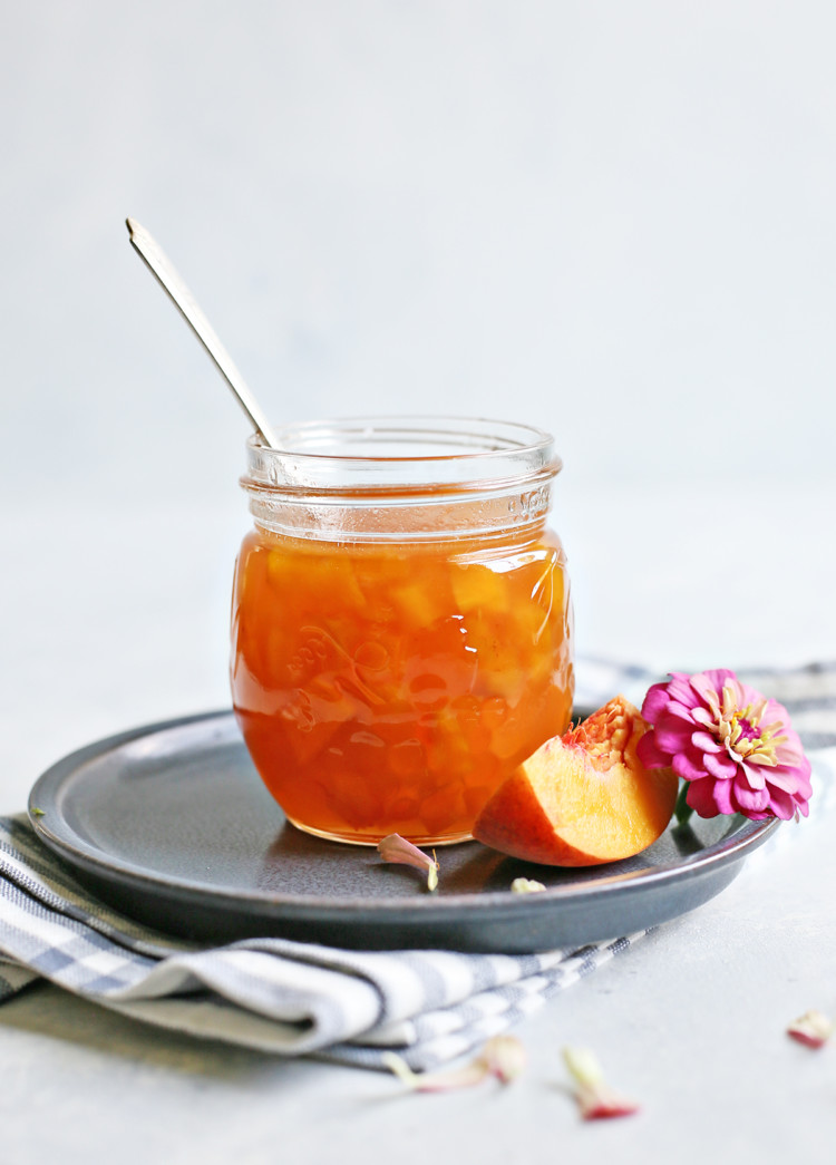 peach syrup in a jar with a spoon